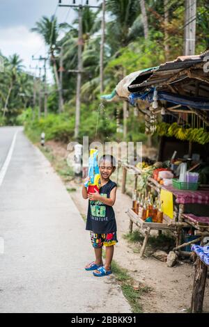 Kleiner Junge mit watergun, Songkran auf der Straße, Ko Pha Ngan Insel, Thailand, Asien Stockfoto