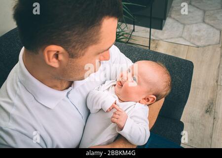 Porträt eines Neugeborenen. Vater hält ein Kind in den Armen. Das erste Lebensjahr. Pflege und Gesundheit. Nahkonzept Stockfoto