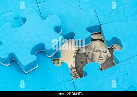 US-Dollar-Banknote versteckt unter Puzzle, Finanzkonzept Stockfoto