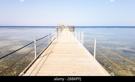 Langer Ponton am Roten Meer in Ägypten. Ponton für den Abstieg ins Wasser. Holzbrücke auf dem Gebiet des Amway Hotel in Sharm El Sheikh mit Stockfoto