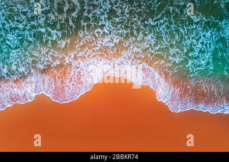 Luftaufnahme von Wellen im Meer und Sandstrand. Stockfoto