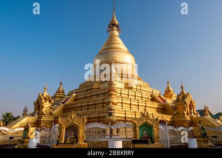 Die Kuthadaw-Pagode, Mondalay, Myanmar. Schöne goldene Kuppel kontrastiert mit hellblauem Himmelshintergrund Stockfoto