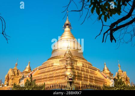 Die Kuthadaw-Pagode, Mondalay, Myanmar. Schöne goldene Kuppel kontrastiert mit hellblauem Himmelshintergrund Stockfoto