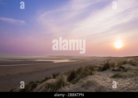Wunderschöner Sonnenuntergang in Camber Sands mit rosa und lila Himmel. Camber Sands, England, Großbritannien Stockfoto