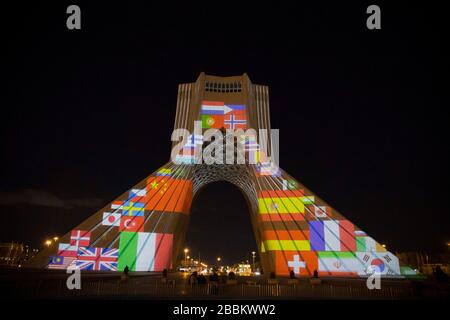 31. März 2020, Teheran, Iran: Ein Blick in der Nacht auf den beleuchteten Azadi (Freiheit)-Turm mit Flaggen, Sympathiebotschaften aus aller Welt über die andauernde neuartige Coronavirus Disease (COVID-19)-Pandemie in Teheran, Iran. Die Wertschätzung wurde auch von Angehörigen der Gesundheitsberufe deutlich, die versuchen, die Pandemie im Land zu stoppen. Die Lichtanzeige wurde von der Stadtgemeinde organisiert. Nach neuesten Berichten des iranischen Gesundheitsministeriums sind über 2.000 Menschen an der Coronavirus-Infektion im ganzen Land gestorben. (Bild: © Rouzbeh Fouladi/ZUMA Draht) Stockfoto