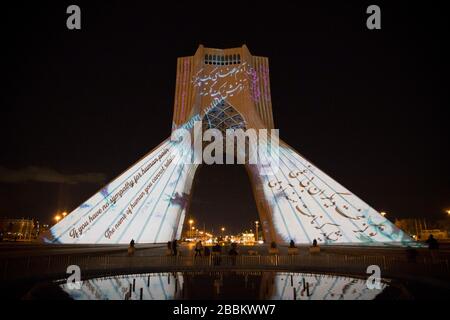 31. März 2020, Teheran, Iran: Ein Blick in der Nacht auf den beleuchteten Azadi (Freiheit)-Turm mit Flaggen, Sympathiebotschaften aus aller Welt über die andauernde neuartige Coronavirus Disease (COVID-19)-Pandemie in Teheran, Iran. Die Wertschätzung wurde auch von Angehörigen der Gesundheitsberufe deutlich, die versuchen, die Pandemie im Land zu stoppen. Die Lichtanzeige wurde von der Stadtgemeinde organisiert. Nach neuesten Berichten des iranischen Gesundheitsministeriums sind über 2.000 Menschen an der Coronavirus-Infektion im ganzen Land gestorben. (Bild: © Rouzbeh Fouladi/ZUMA Draht) Stockfoto