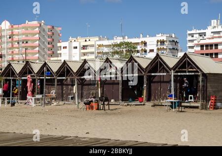 Monte Gordo, Portugal - 18. November 2019: Fischer entspannen und arbeiten in ihren Holzhütten am Strand von Monte Gordo an der portugiesischen Algarv Stockfoto