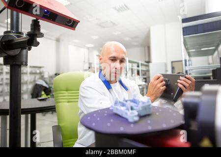 Qualitätsingenieur, der einige Formteile mit einem professionellen optischen 3D-Scanner scannt, Fahrzeugkonzept Stockfoto