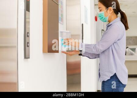 Frau, die eine Schutzmaske trägt und die Hand mit Alkoholgel waschen kann. Stockfoto