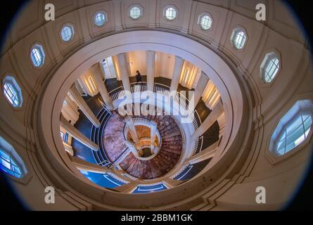 Schwerin, Deutschland. April 2020. Ein Landtagsabgeordneter läuft über eine Ebene der Roten Marmortreppe im Schweriner Schloss. Das historische Gebäude ist eine Landtagssitzung und ein Museum. Wegen der Corona-Krise ist das Schloss für Museumsbesucher gesperrt. Kredit: Jens Büttner / dpa-Zentralbild / dpa / Alamy Live News Stockfoto