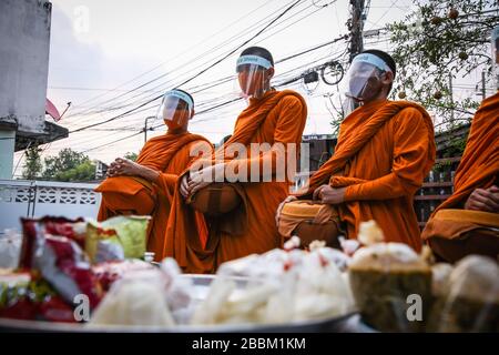 Thailändische Mönche, die Schutzmasken als präventive Maßnahme gegen die Ausbreitung der COVID-19-Pandemie tragen, erhalten Almosen in Bangkok. Das thailändische Ministerium für öffentliche Gesundheit berichtet von 120 neuen Fällen von Coronavirus (Covid-19), wodurch die Gesamtzahl auf 1.771 und 12 Todesfälle angehoben wird. Stockfoto