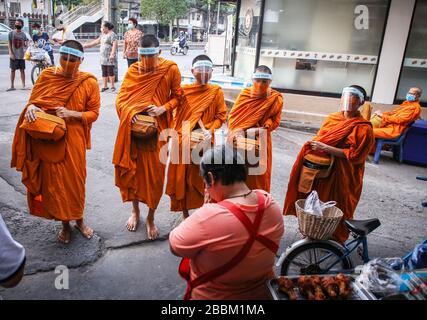 Thailändische Mönche, die Schutzmasken als präventive Maßnahme gegen die Ausbreitung der COVID-19-Pandemie tragen, erhalten Almosen in Bangkok. Das thailändische Ministerium für öffentliche Gesundheit berichtet von 120 neuen Fällen von Coronavirus (Covid-19), wodurch die Gesamtzahl auf 1.771 und 12 Todesfälle angehoben wird. Stockfoto