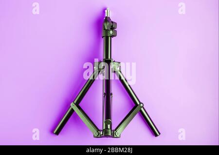 Stativ auf pinkfarbenem Hintergrund für Foto-Videokamera und Blitz. Freier Speicherplatz Stockfoto