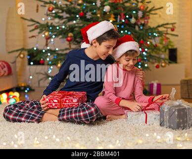 Fröhliche Kinder mit Geschenken zur Weihnachtszeit Stockfoto