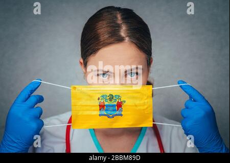 Coronavirus im US-Bundesstaat New Jersey, weibliches Doktorporträt, schützen Sie die chirurgische Gesichtsmaske mit der New-Jersey-Flagge. Krankheit, Virus Covid-19 in Neu Stockfoto