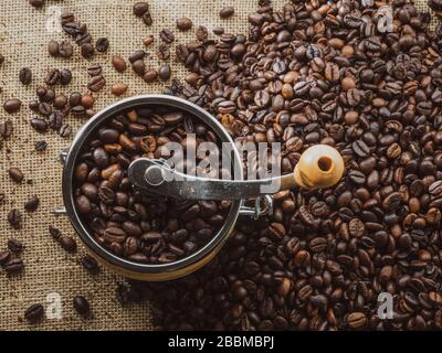 Hoher Draufsicht auf die Kaffeemühle mit gerösteten Kaffeebohnen auf dem Tisch Stockfoto