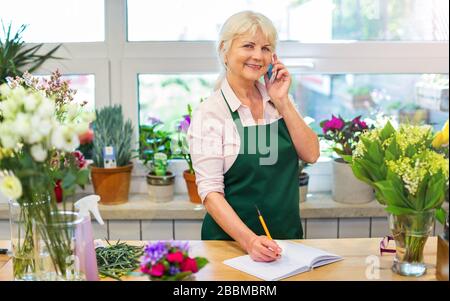 Seniorin, die im Blumengeschäft arbeitet Stockfoto