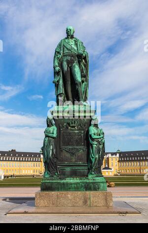 Denkmal von Karl Friedrich von Baden mit Schloss Karlsruhe im Hintergrund und blauem Himmel. Karlsruhe, Baden-Württemberg, Deutschland Stockfoto