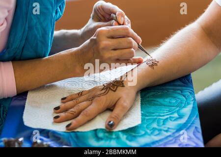Henna, das auf der Hand einer Frau malt Stockfoto