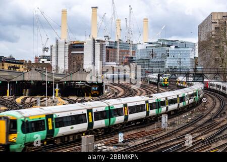 Ein Südzug, der zum Bahnhof Victoria London mit Battersea Power Station im Hintergrund eintrifft Stockfoto