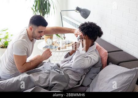 Im Bett Paar mit Grippe und hoher Temperatur Stockfoto