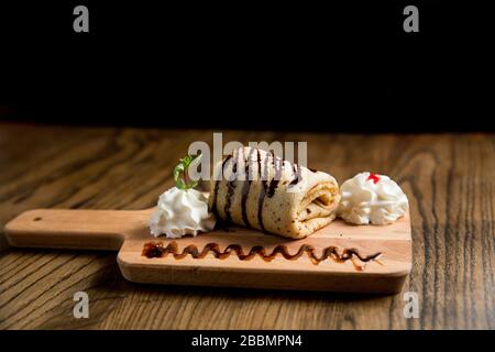 Frisch gebackene Pfannkuchenrolle auf der Holzplatte Stockfoto