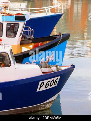 Die Bogen von drei blauen Fischerbooten, die im Camber Dock, Portsmouth, Hampshire, England, Großbritannien, gebeugt wurden Stockfoto