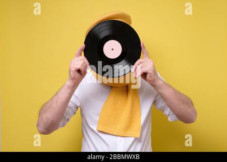 Fröhlicher Mann hält das Vinyl in der Hand Stockfoto