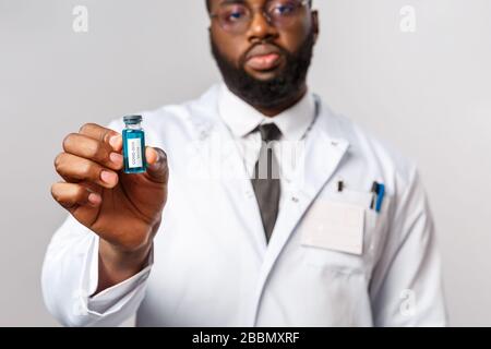 Konzept für medizinische, medizinische und Krankenhausbehandlung. Ernst aussehender Wissenschaftler, afroamerikanischer Arzt im Labor, der brandneue Arbeit zeigt Stockfoto