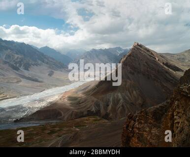 Der Fluss Spiti mäandert durch ein tiefes Tal, das an einem schönen Sommertag in der Nähe von Kazua, Himachal Pradesh, Indien von den hohen Gipfeln des Himalayas flankiert wird. Stockfoto