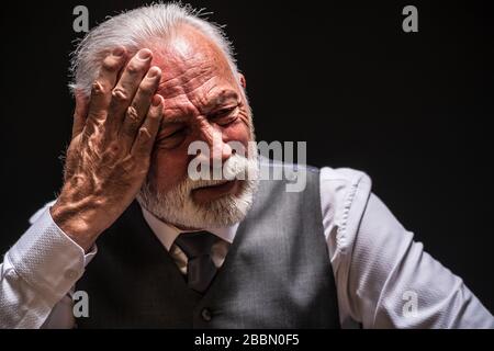 Porträt des depressiven Seniors auf schwarzem Hintergrund. Stockfoto