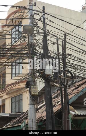 Jakarta, Indonesien - 13. Juli 2019: Pole, die mit einem Gewirr aus schwarzen unterirdischen Stromkabeln beladen sind, auf den Straßen von Zentral-Jakarta. Stockfoto