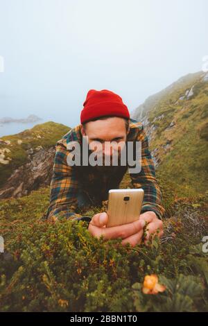 Mann mit Smartphone Foto von Wolkenkraut gehen im Freien moderne Technologie Einflussnehmer Blogger Lifestyle Sommerferien in Norwegen Stockfoto
