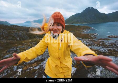 Frau, die in Norwegen unterwegs ist, Berge windig Wetter Urlaub im Freien Abenteuer Lifestyle emotionales Mädchen mit gelbem Regenmantel skandinavische Reise Stockfoto