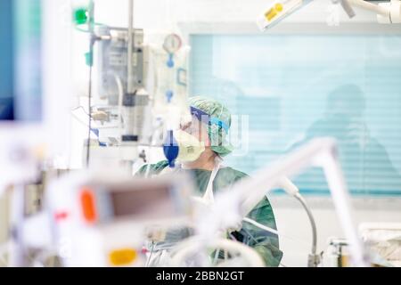 Essen, Deutschland. April 2020. Eine Krankenschwester arbeitet in Schutzkleidung in einem Krankenhauszimmer in der Intensivstation des Universitätsklinikums Essen, in dem ein Corona-Patient aus Frankreich behandelt wird. Heute wurden weitere schwer an Covid-19 erkrankte Patienten von Frankreich nach Essen geflogen. Credit: Marcel Kusch / dpa / Alamy Live News Stockfoto