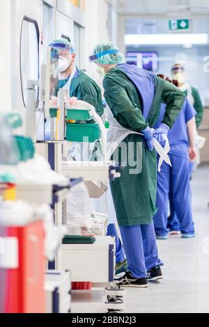 Essen, Deutschland. April 2020. Krankenschwestern in Schutzkleidung betreten einen Krankenhausraum in der Intensivstation des Universitätsklinikums Essen, in dem ein Corona-Patient aus Frankreich behandelt wird. Heute wurden weitere schwer an Covid-19 erkrankte Patienten von Frankreich nach Essen geflogen. Credit: Marcel Kusch / dpa / Alamy Live News Stockfoto