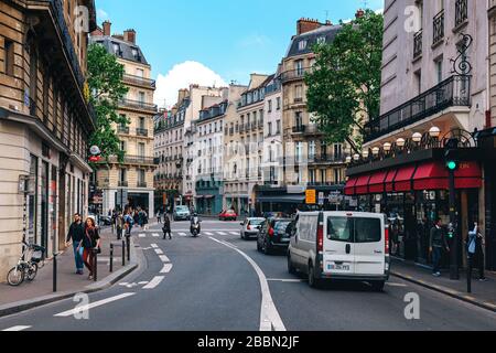 Menschen, die auf der Straße zwischen typischen pariser Gebäuden im Zentrum von Paris, Frankreich, spazieren gehen. Stockfoto