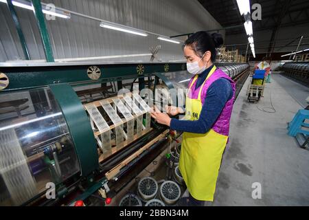 (200401) -- RONGJIANG, 1. April 2020 (Xinhua) -- Menschen arbeiten in einem Seidenunternehmen im Kreis Rongjiang im Südwesten Chinas Provinz Guizhou, 1. April 2020. Als eine der neun von Armut betroffenen Counties in der Provinz Guizhou, die nicht aus der Armut herausgehoben wurden, hat sich der Kreis Rongjiang darauf konzentriert, die Wiederaufnahme der Produktion von Unternehmen im Landkreis und den Export von Arbeitsdiensten seit Februar zu fördern. Bisher waren mehr als 140.000 Menschen unter den vorhandenen 190.000 Arbeitern im Rongjiang County beschäftigt. (Xinhua/Yang Ying) Stockfoto