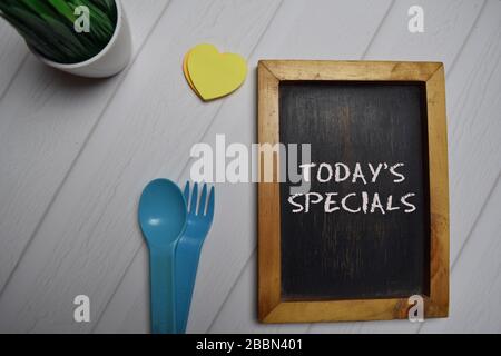 Die heutigen Specials schreiben auf ein schwarzes Brett, das auf dem Schreibtisch isoliert ist. Stockfoto