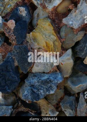 Verschiedene Arten von bunten Steinen in verschiedenen Formen. Nahaufnahme von mehrfarbigen Steinen an der Wand für den Hintergrund. Stockfoto