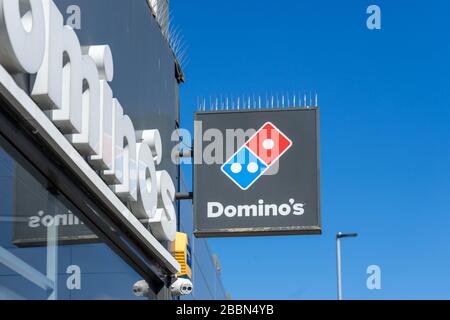Das Schild an der Außenseite eines Domino's Take Away Pizza-Shops Stockfoto
