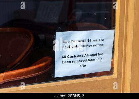 Ein Schild im Fenster einer Kneipe, das angibt, dass sie aufgrund von Covid-19 oder Coronavirus geschlossen sind Stockfoto