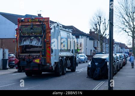 Ein Müllsammelwagen oder Müllwagen, der eine englische Straße hinunterfährt Stockfoto