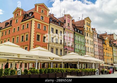 Ein Restaurant und die Sitzplätze der Brauerei neben bunten Gebäuden auf dem rynek Marktplatz, dem Zentrum von Wroclaw, Polen. Juli 2017. Stockfoto