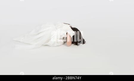 Junge Frau in weißem Kleid auf dem Boden niederwerfen Stockfoto