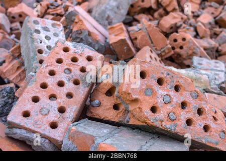 Alte und zerbrochene Ziegelsteine wurden nach dem Abriss eines Gebäudes in einen Haufen geworfen Stockfoto