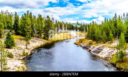 Heißes Wasser aus dem Middle Chain Lake Geyser und den umliegenden heißen Quellen, das in den Firehole River im Yellowstone National Park fließt Stockfoto