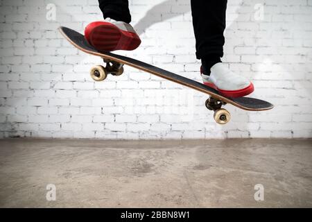 Skateboarder, der Skateboard-Trick ausführt - Ollie auf Beton. Athlet übt Sprung und bereitet sich auf den Wettkampf vor. Extremsport, Jugendkultur, Stadt Stockfoto