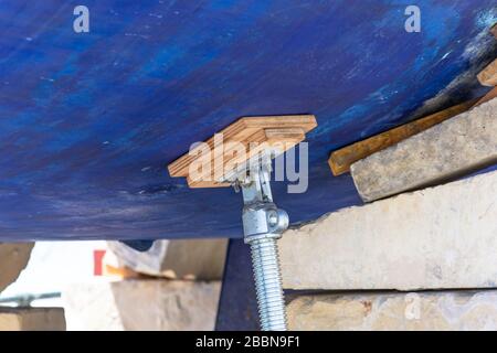 Hydraulischer mechanischer Wagenheber, der von einem Holzbackgefäß getragen wird, unterer Bootshebewerk zur Reparatur Stockfoto
