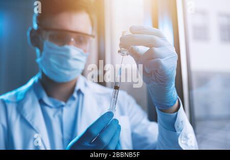 Medic mit Maske arbeitet an einer Lösung für den koviden 19-Virus. Konzept der medizinischen Forschung Stockfoto